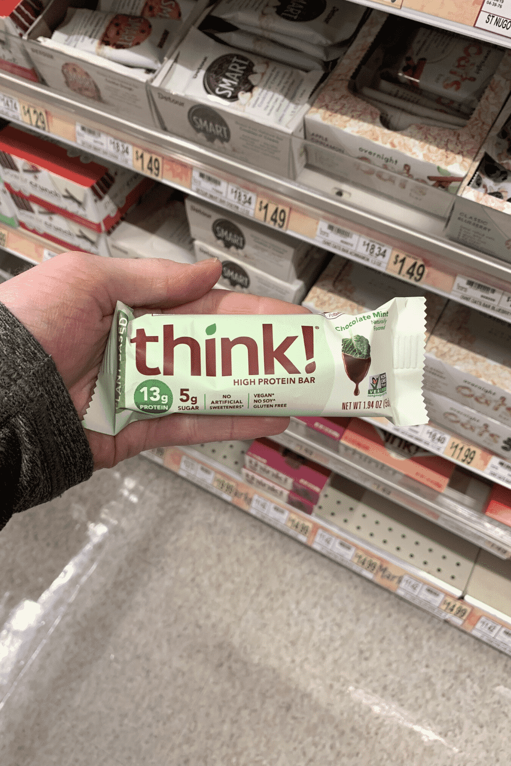 A hand holding a wrapped mint chocolatet hink! bar