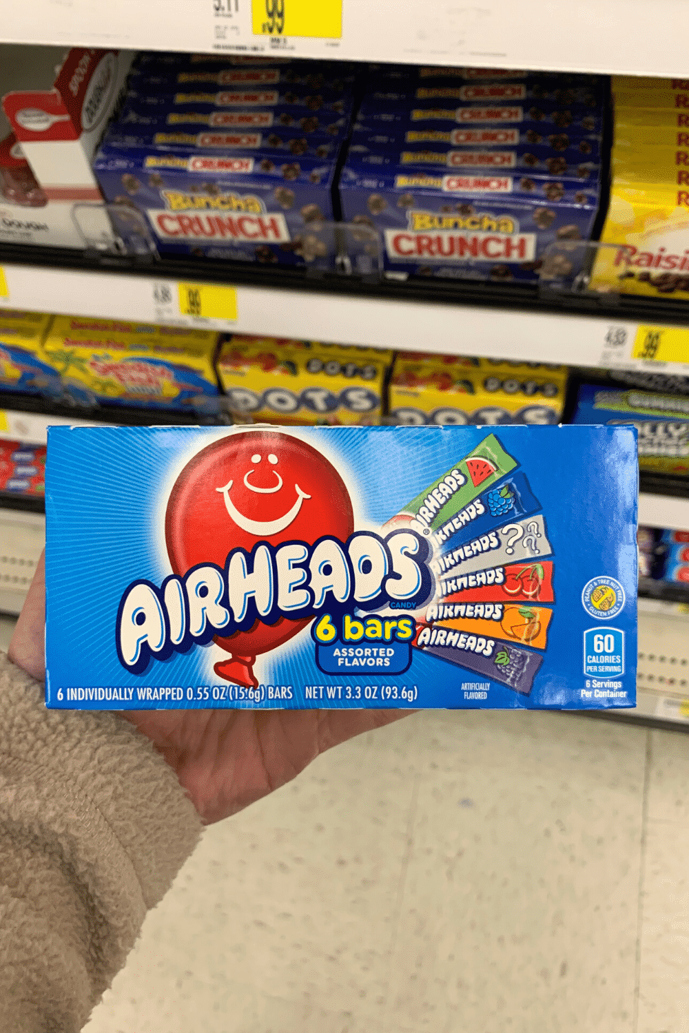 A hand holding a box of Airhead bars