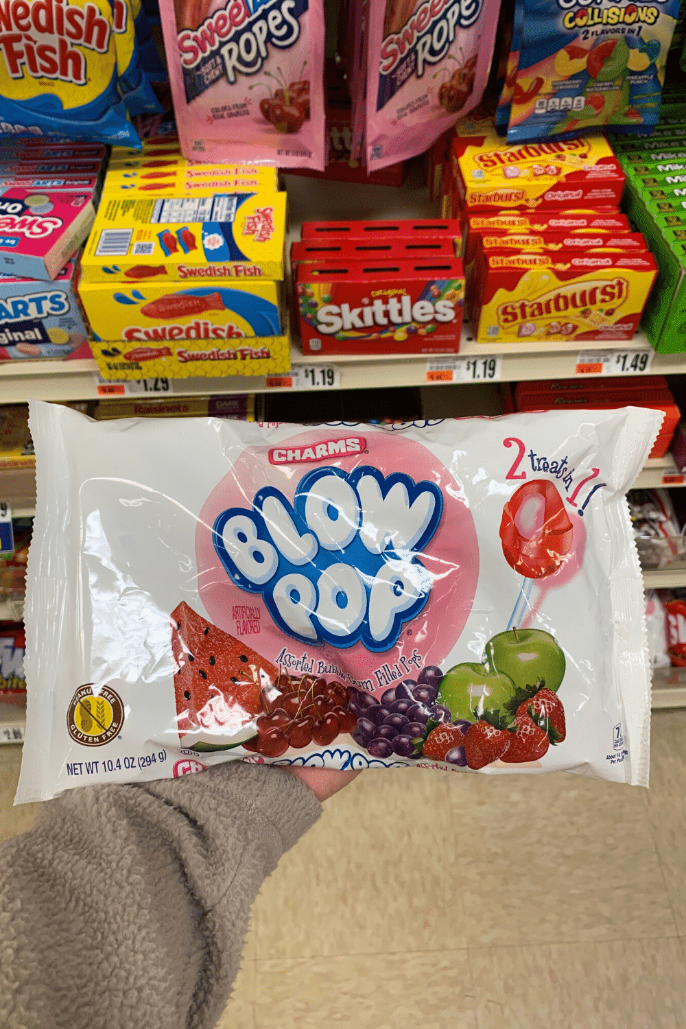 A hand holding a bag of blow pop