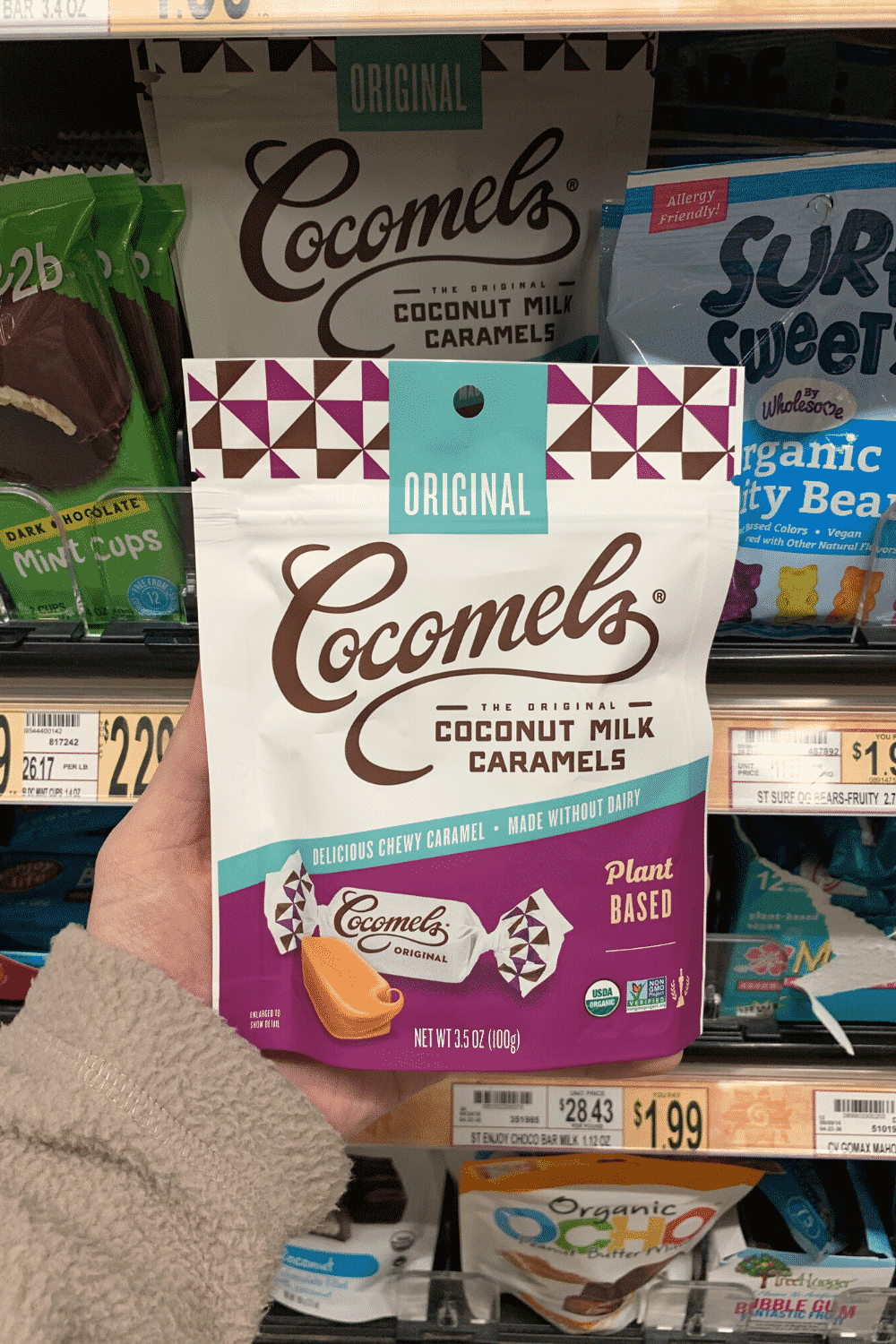 A hand holding a package of cocomels coconut milk caramels