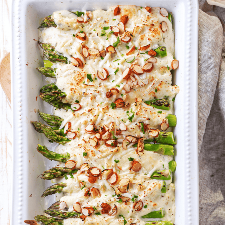 A white casserole dish filled with asparagus casserole.