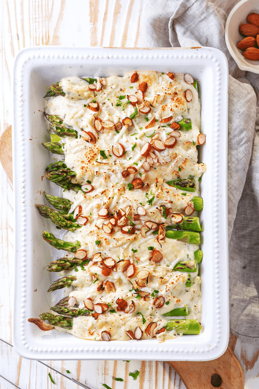 A white casserole dish filled with asparagus casserole.