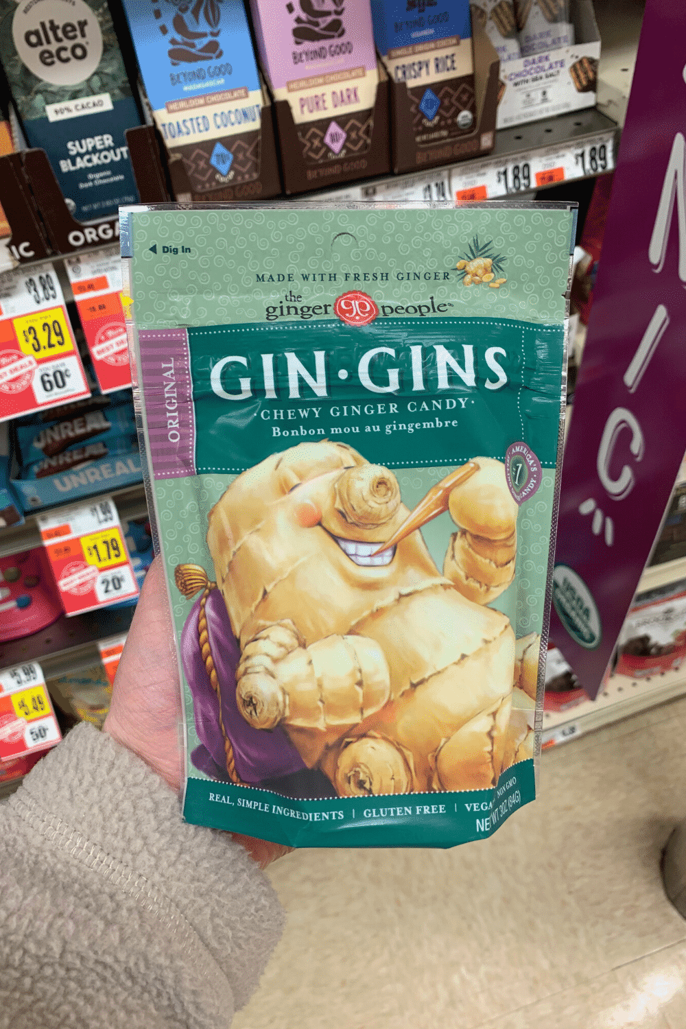 A hand holding a bag of Gin-Gins original chewy ginger candy