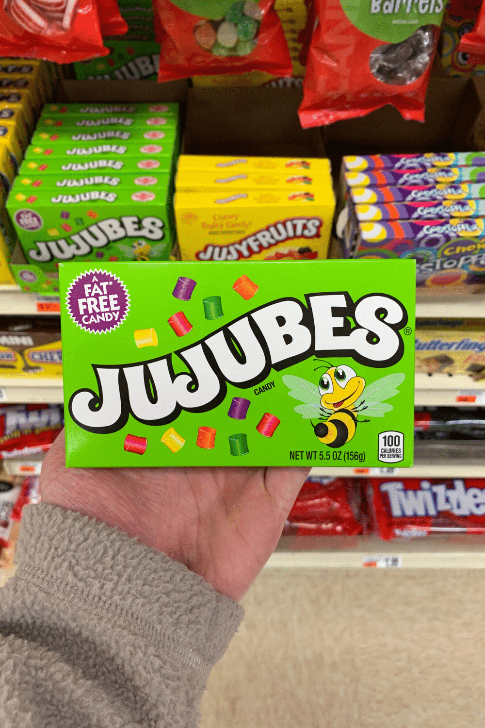 A hand holding a box of Jujubes