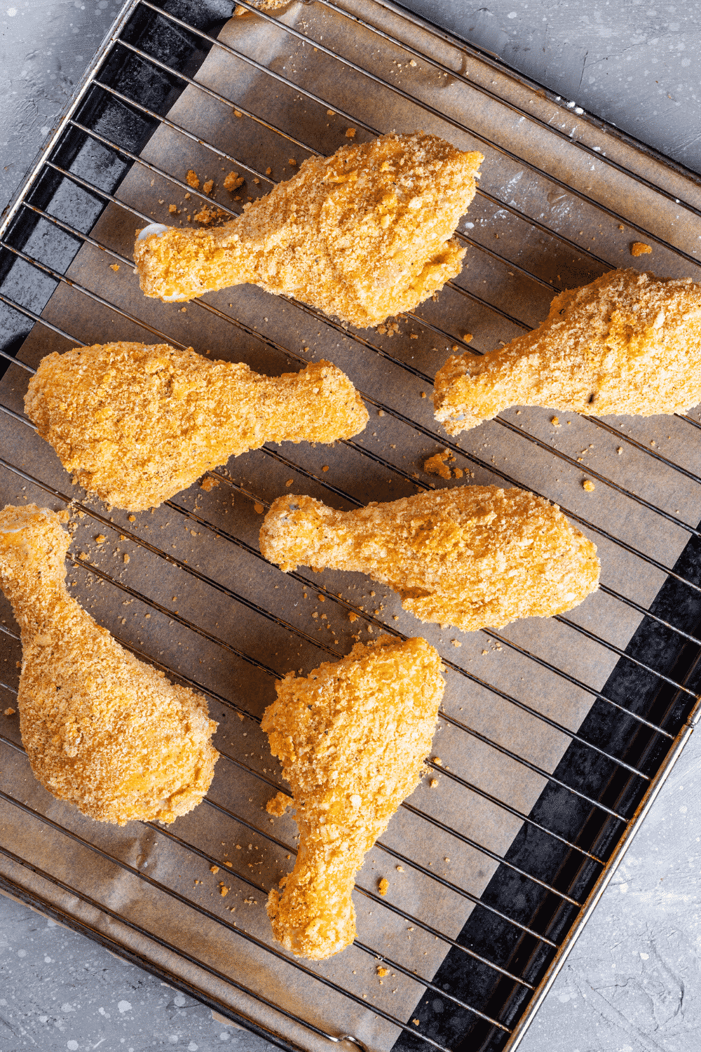 Six pieces of breaded fried chicken on a wire rack.