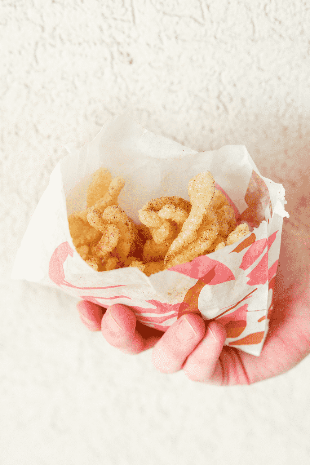 A hand holding a bag of Taco Bell cinnamon twists