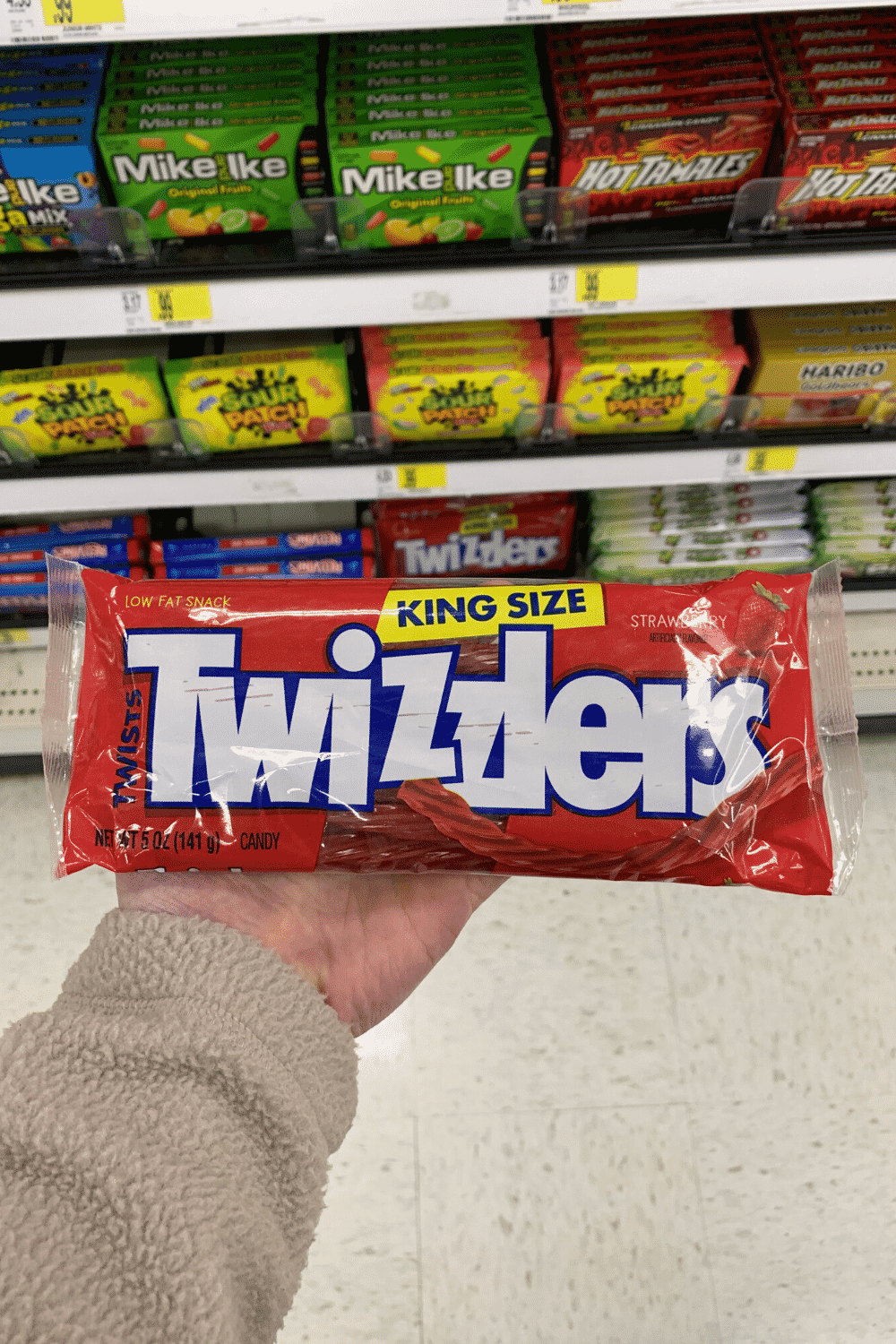 A hand holding a bag of Twizzlers