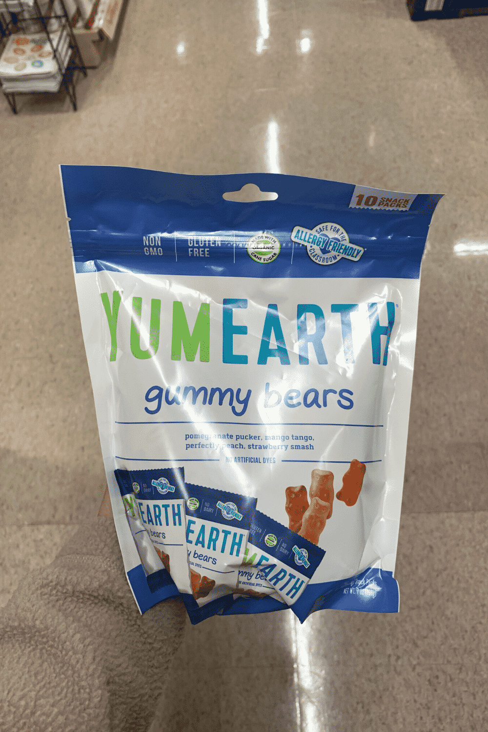 A hand holding a bag of YumEarth gummy bears