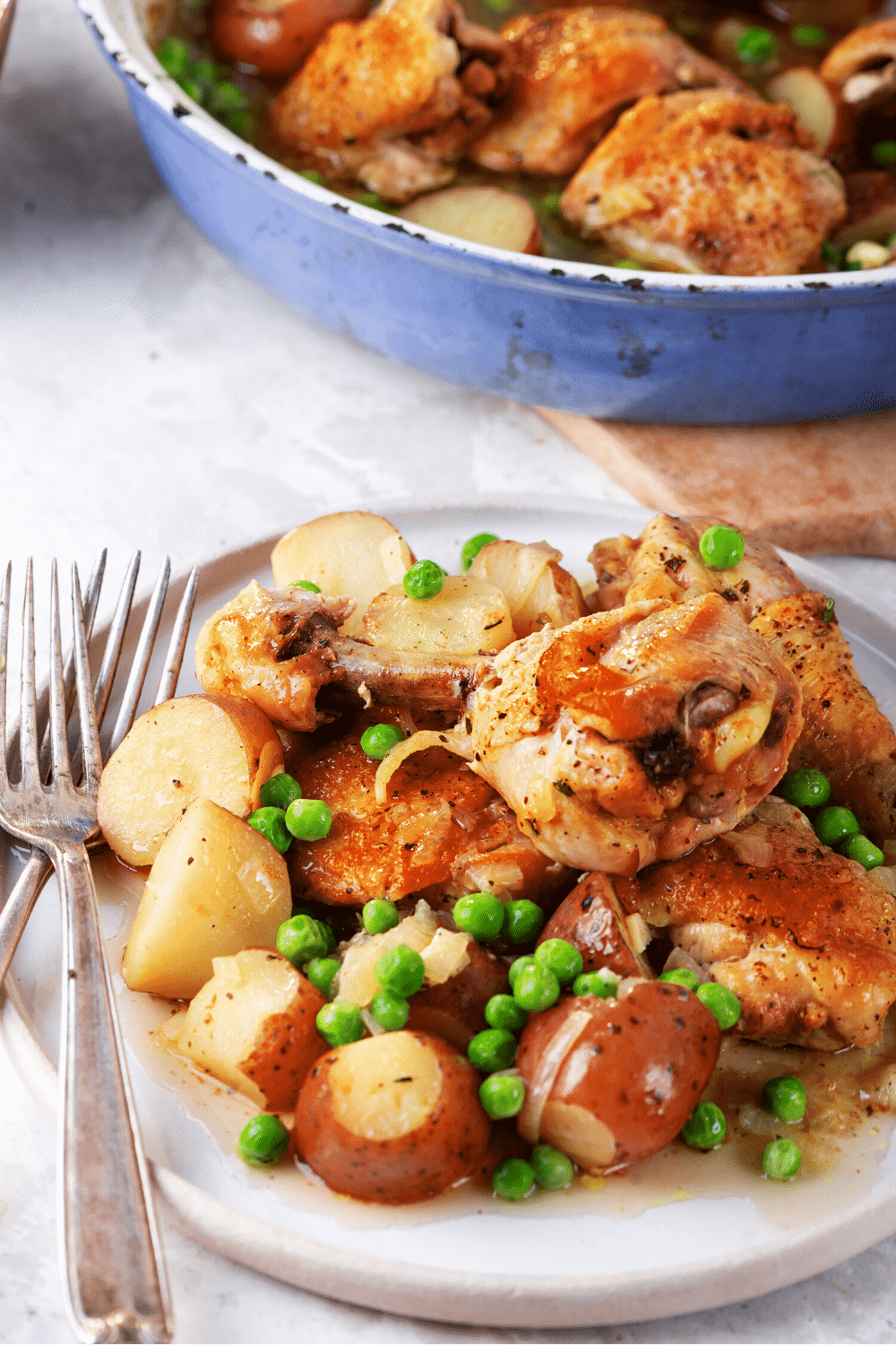 A white plate with chicken Vesuvio on it.