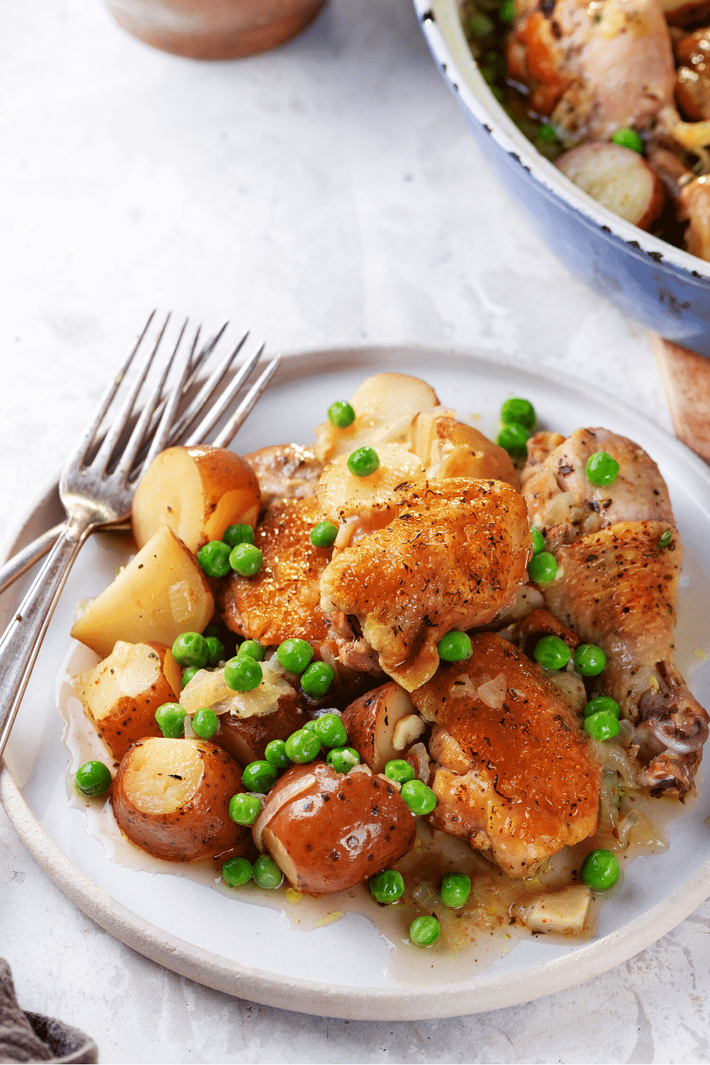 A white plate with chicken Vesuvio.