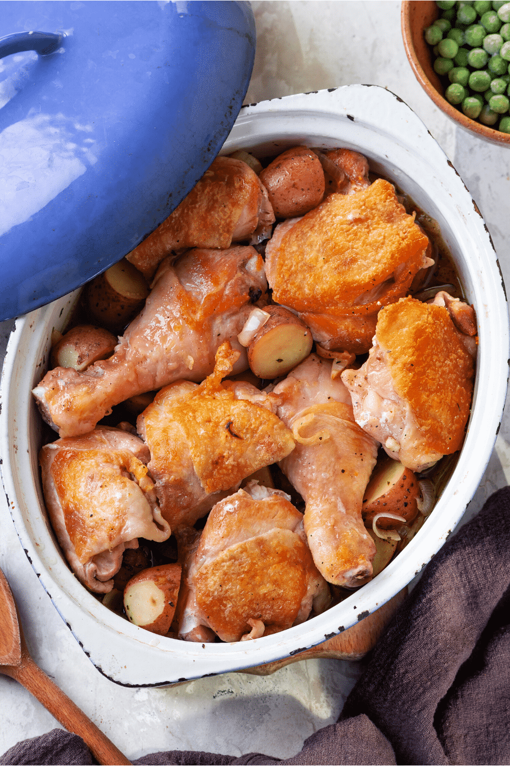 A pot filled with chicken legs and potatoes.