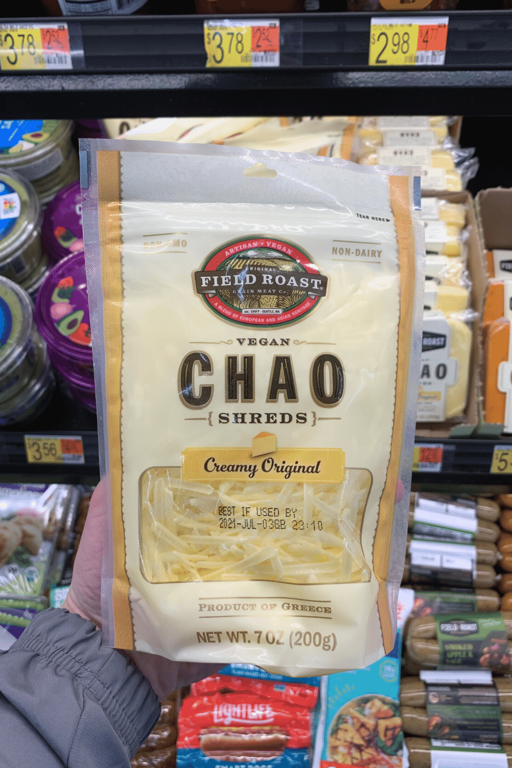 A hand holding Field Roast vegan chao shreds creamy original