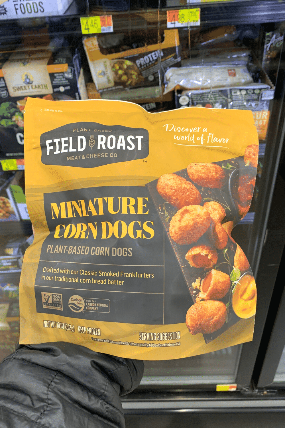 A hand holding field roast miniature corn dogs plant-based corn dogs.