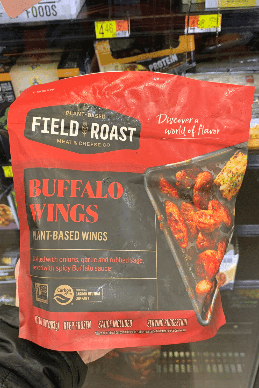 Hand holding field roast plant-based Buffalo wings.