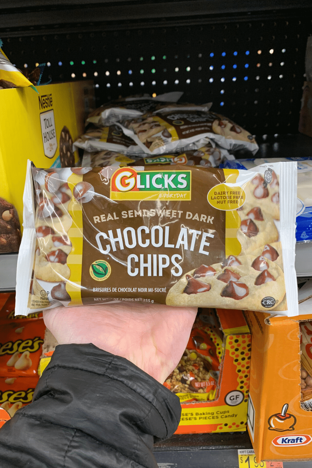 A hand holding Glick's vegan real semi sweet dark chocolate.