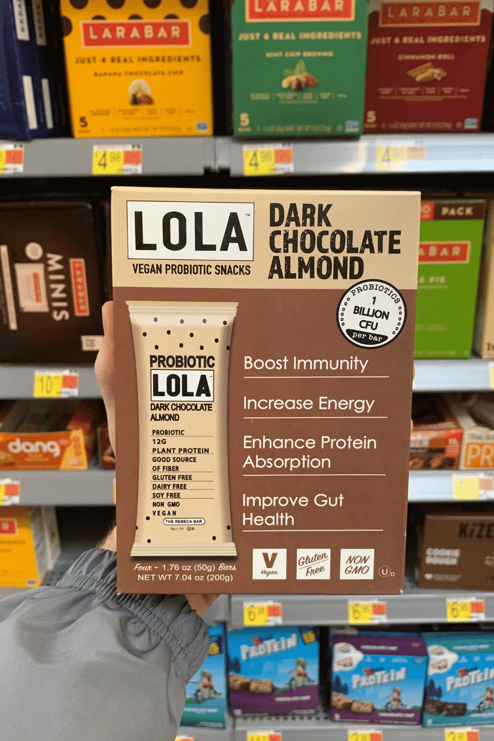 A hand holding Lola dark chocolate almond vegan probiotic snack.