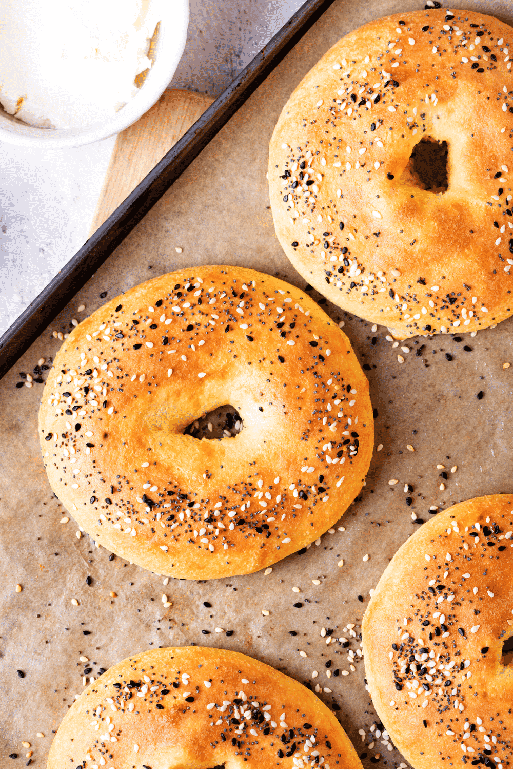 A few bagels on a baking sheet lined with parchment paper.
