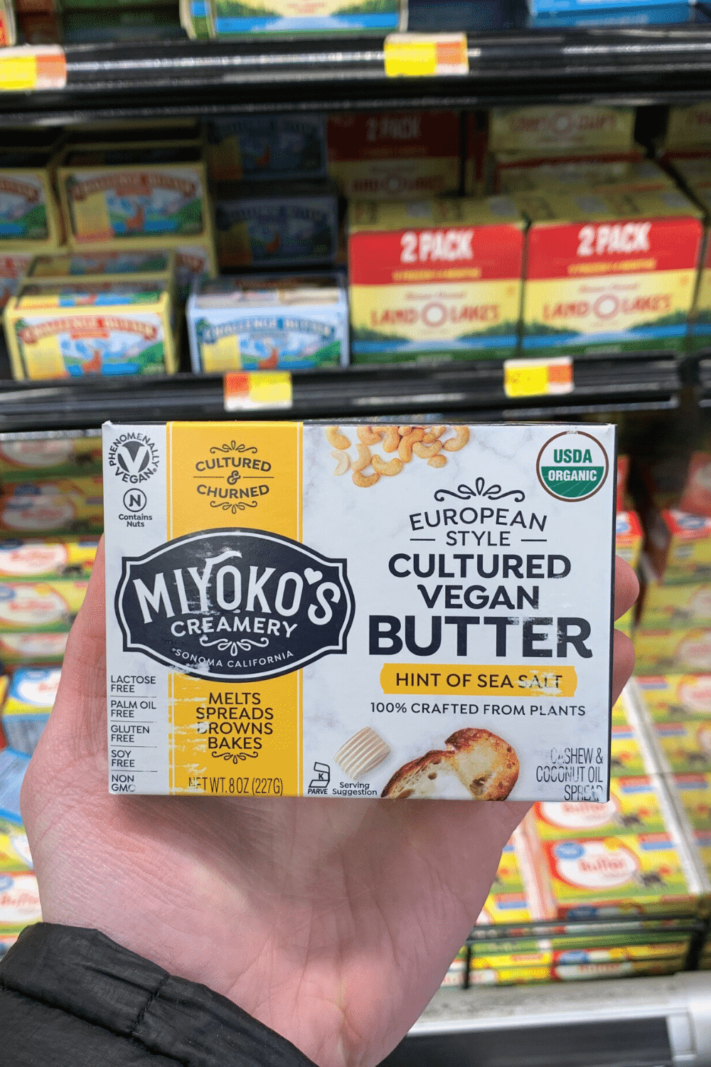 A hand holding Miyoko's creamery cultured vegan butter.