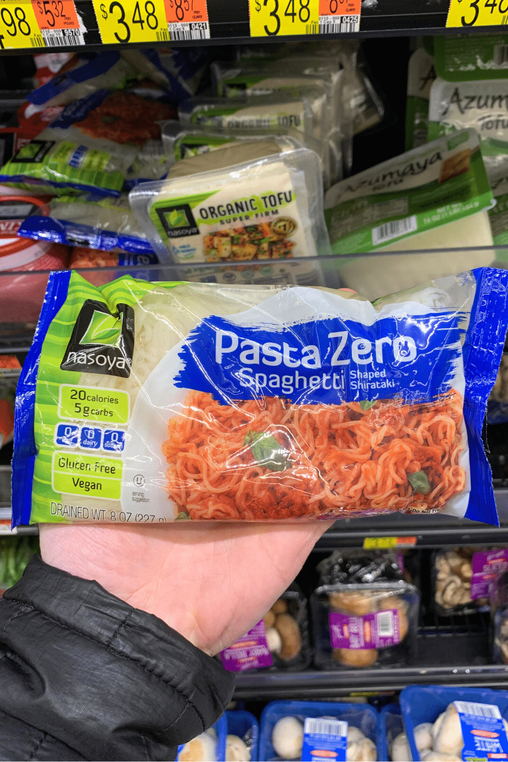 A hand holding nasoya pasta zero spaghetti.