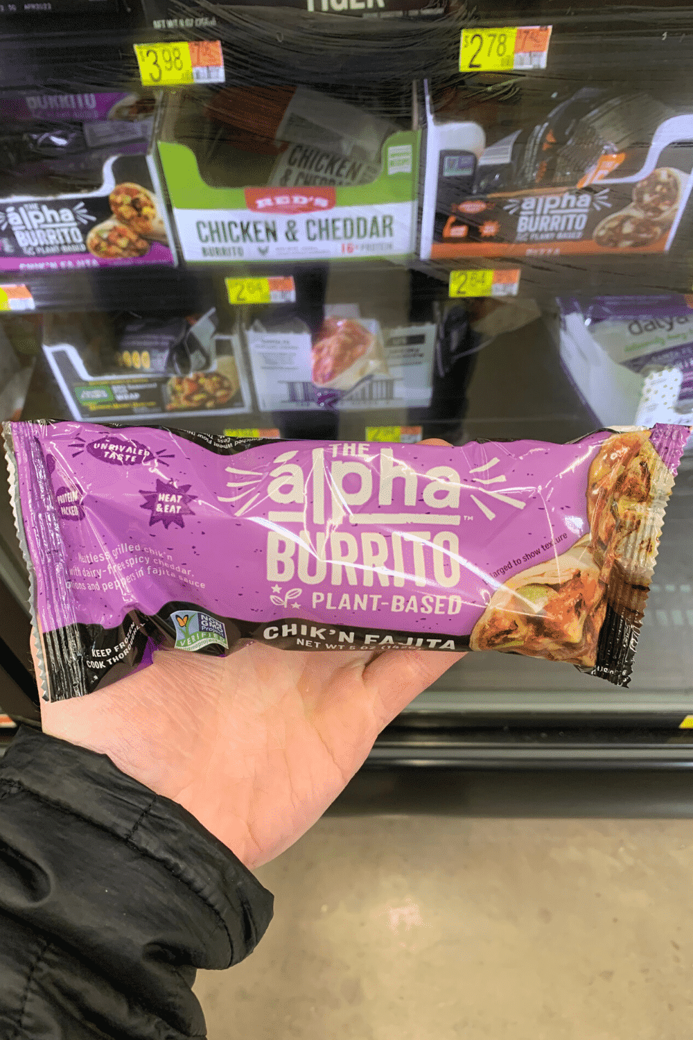A hand holding the Alfa burrito plant-based chik'n fajita.