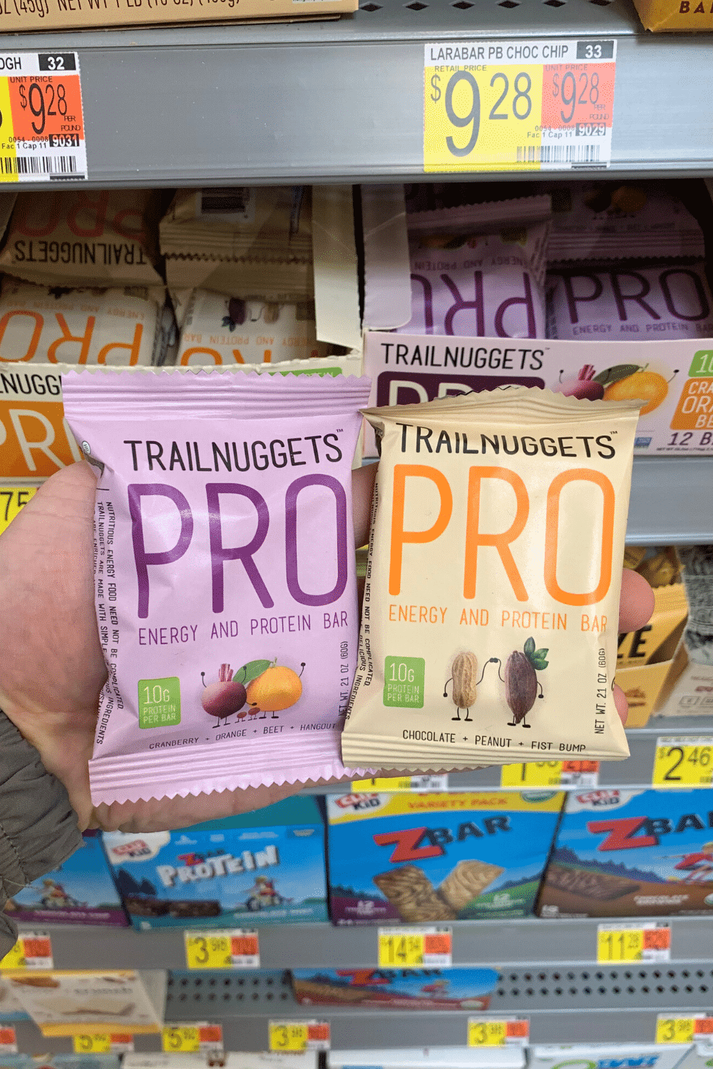 A hand holding trail nuggets pro energy and protein bar.