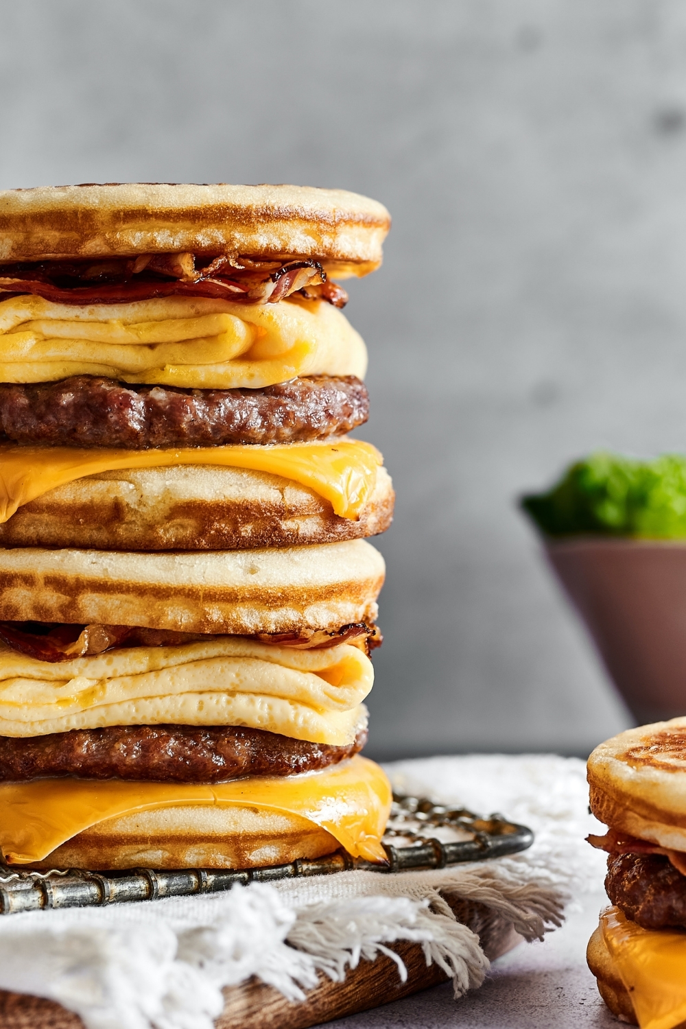 Part of two McGriddles stacked on top of one another on a wire rack on a white tablecloth.