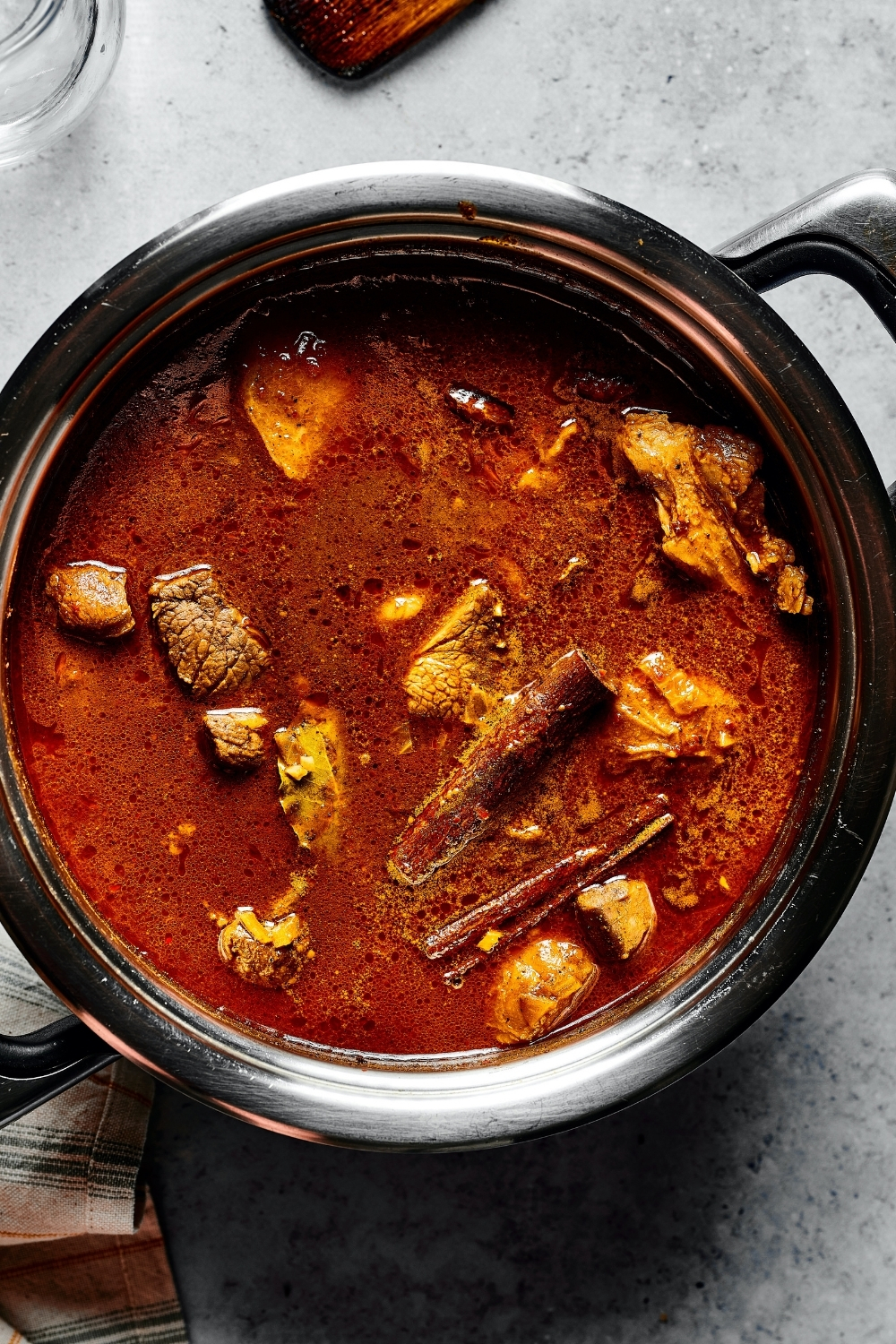 A pot that is filled with lamb vindaloo. The pot is on a grey counter.