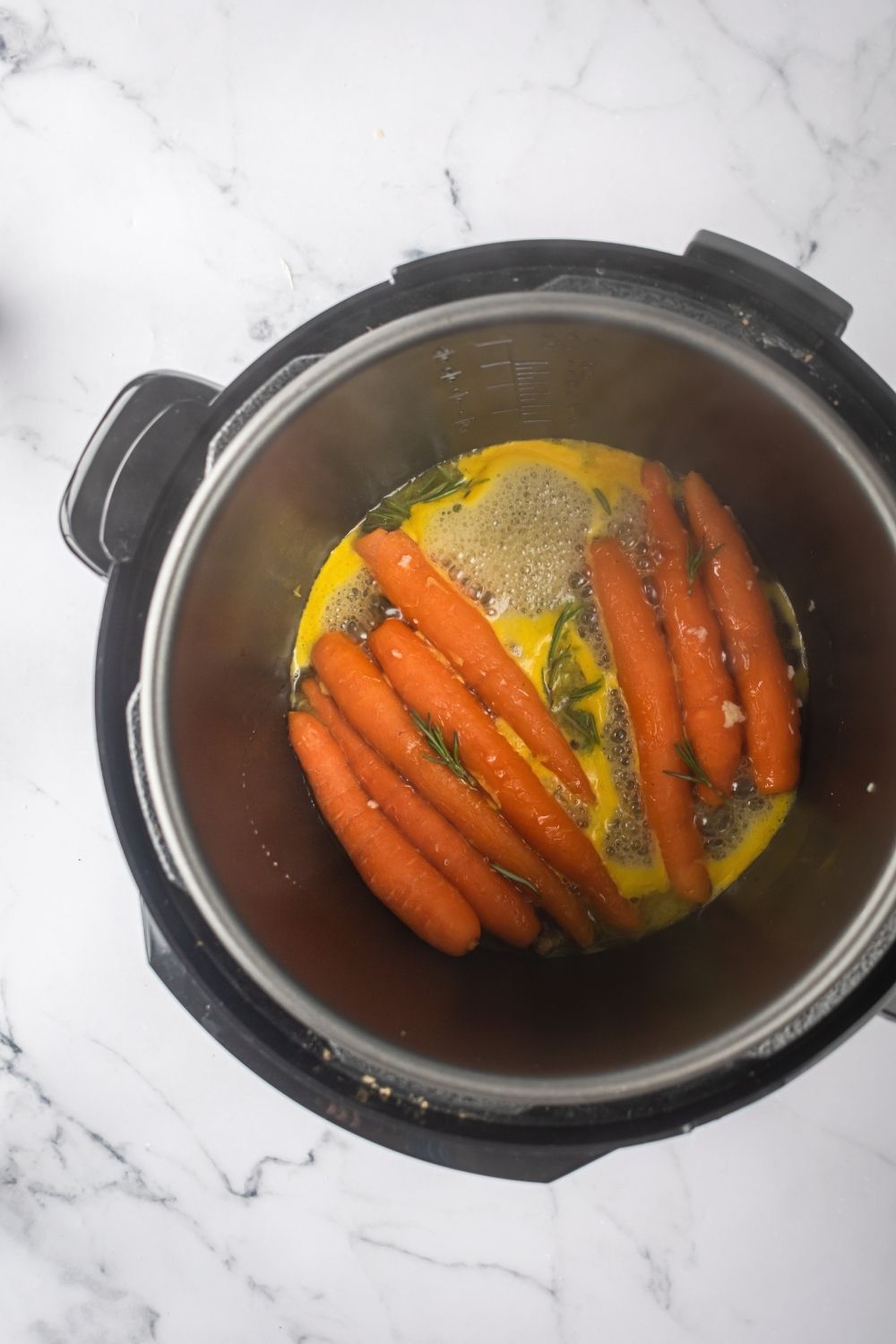 An instant pot with honey glazed carrots cooking in it.