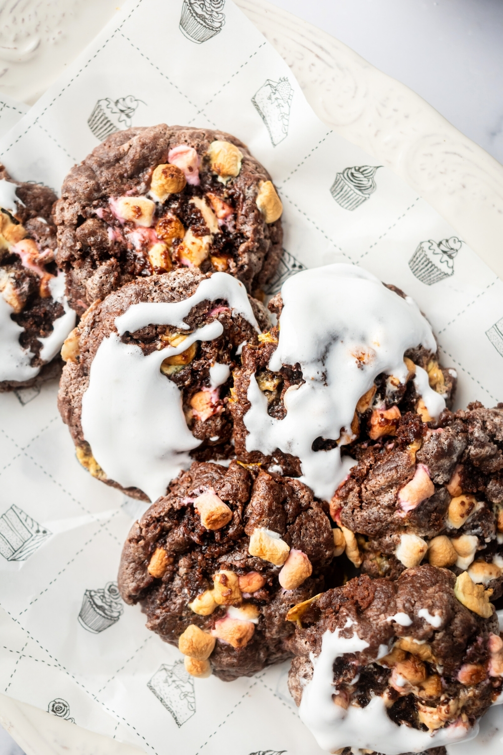 Six marshmallow cookies with fluff on top on a piece of parchment paper.