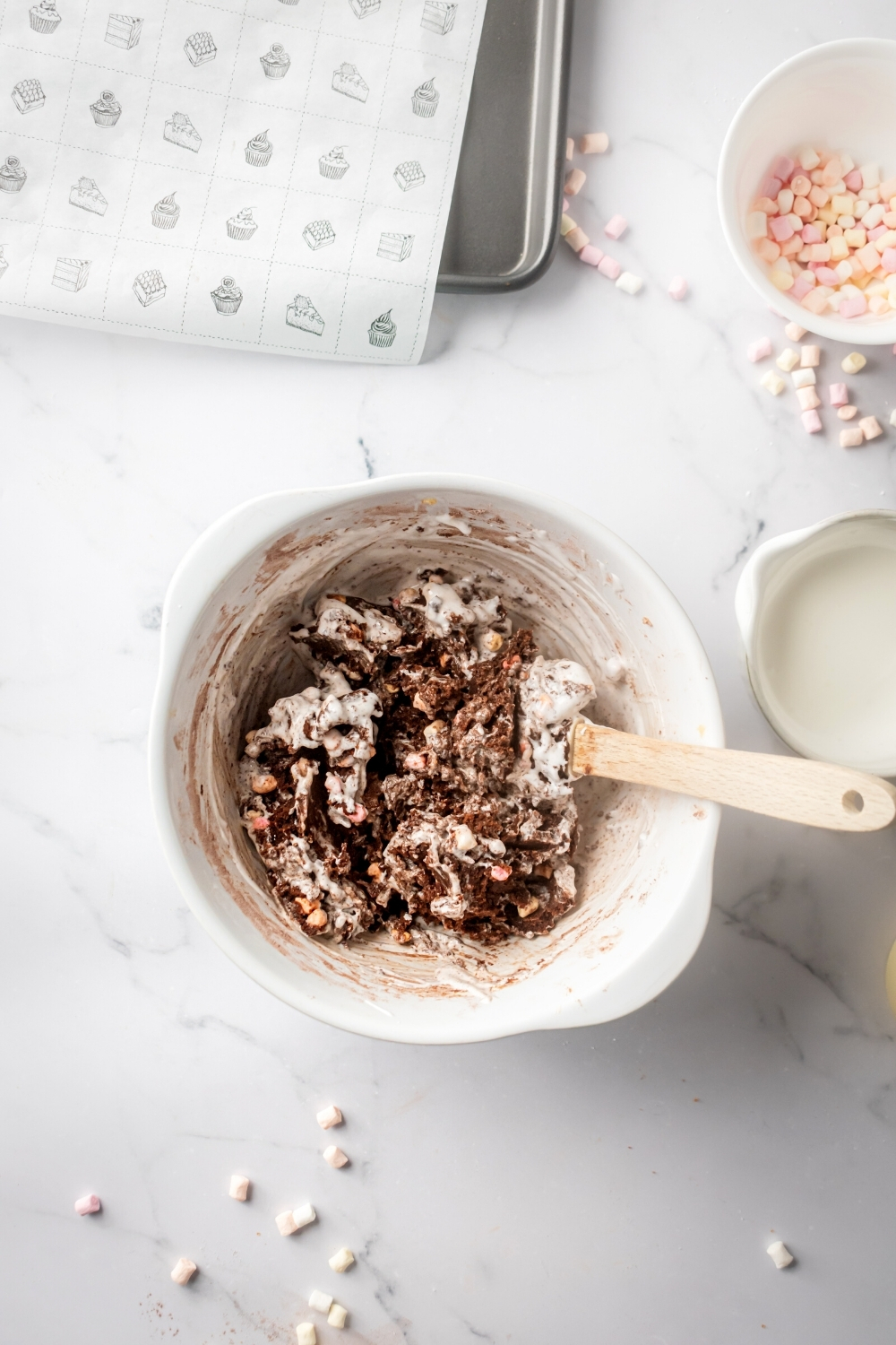 A white mixing bowl with marshmallow cookie dough in it.
