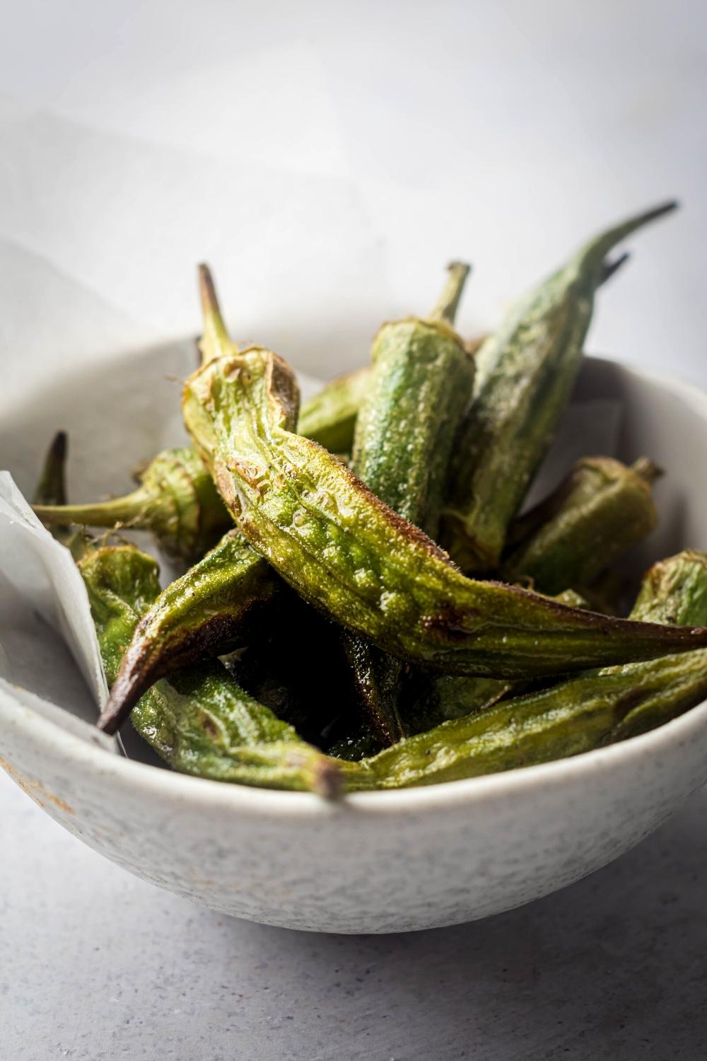 A white bowl that is filled with fried okra.