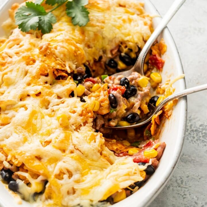 Melted shredded cheese that is on top of ground beef, black beans, corn, crushed nacho cheese flavored Doritos and other Dorito casserole ingredients.