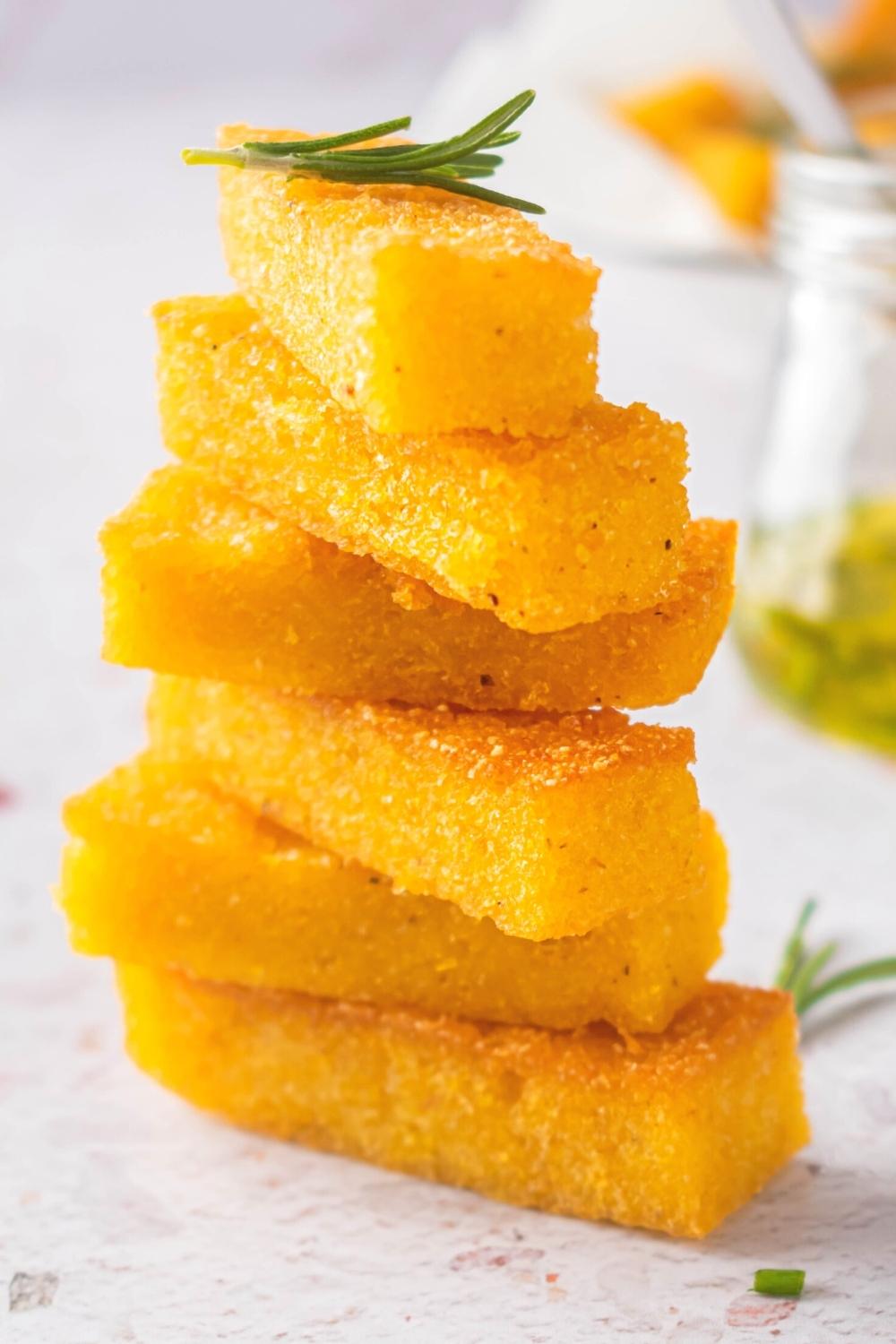 A stack of six polenta sticks on a white counter.