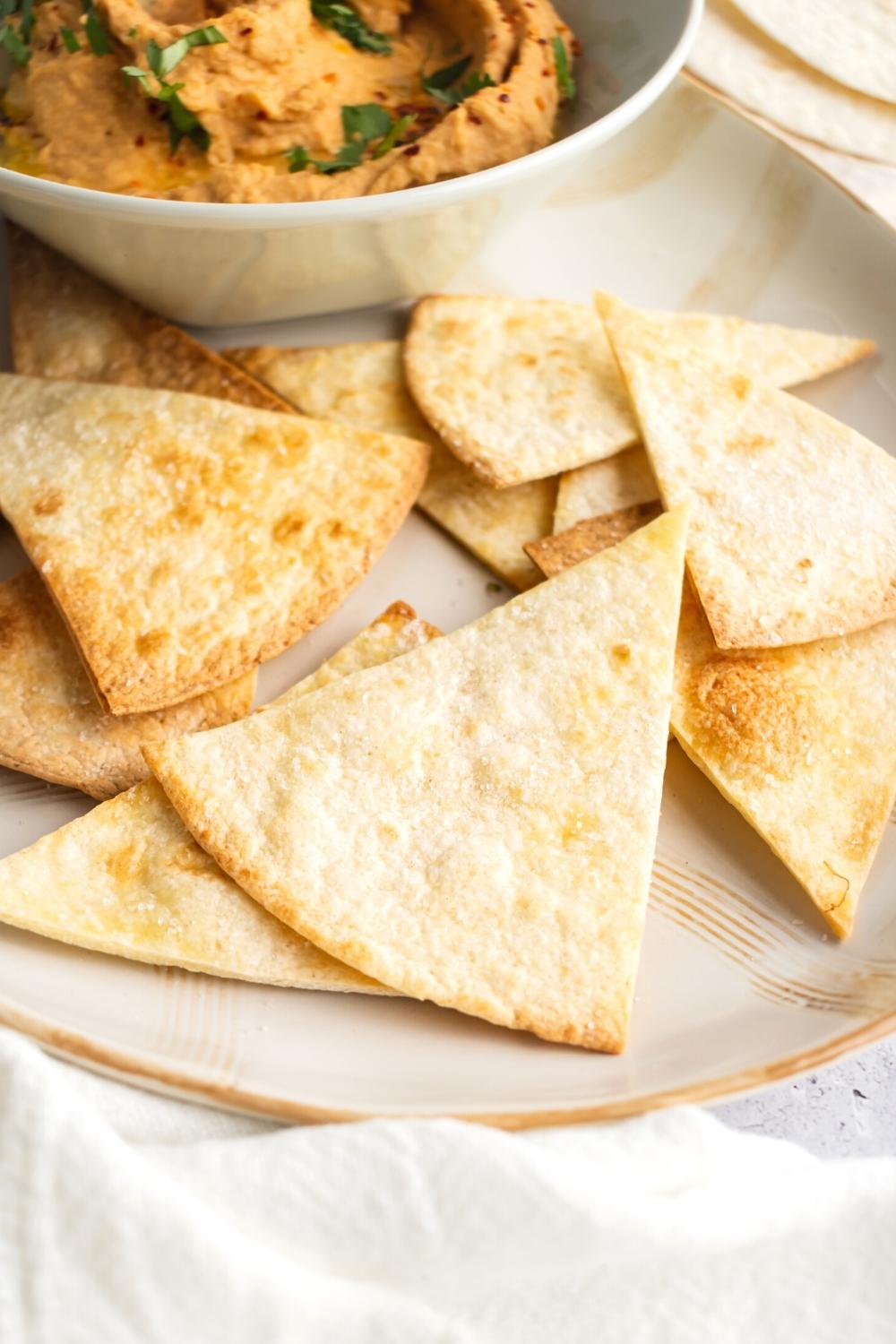 A couple of air fryer tortilla chips on top of one another on part of a plate.