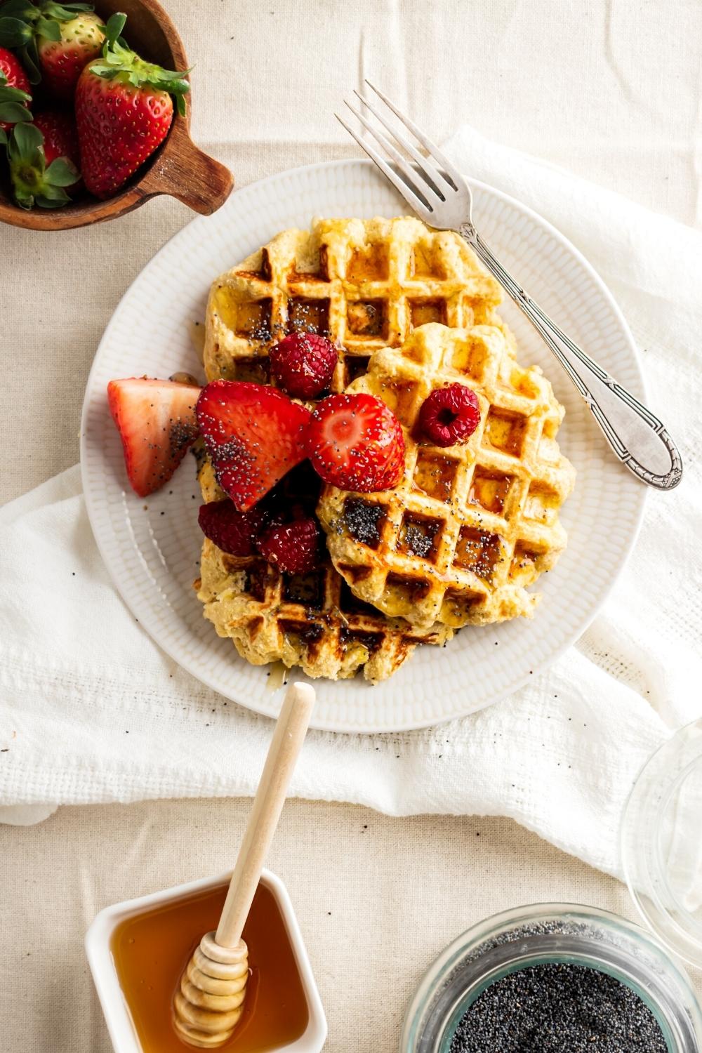 Three banana waffles on a white plate with a fork next to them.