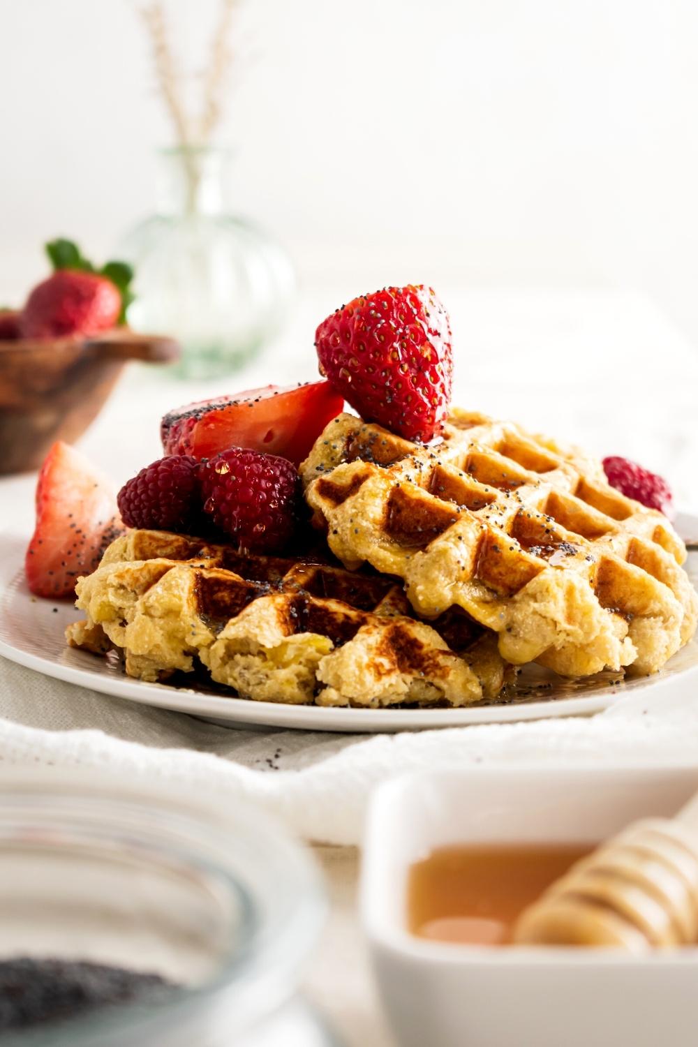 Two healthy waffles overlapping one another on a white plate.