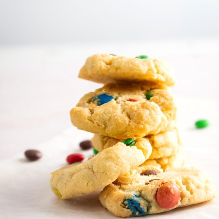 A couple of M&M sugar cookies stacked on top of one another.