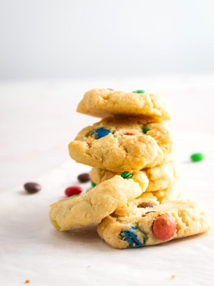 A couple of M&M sugar cookies stacked on top of one another.