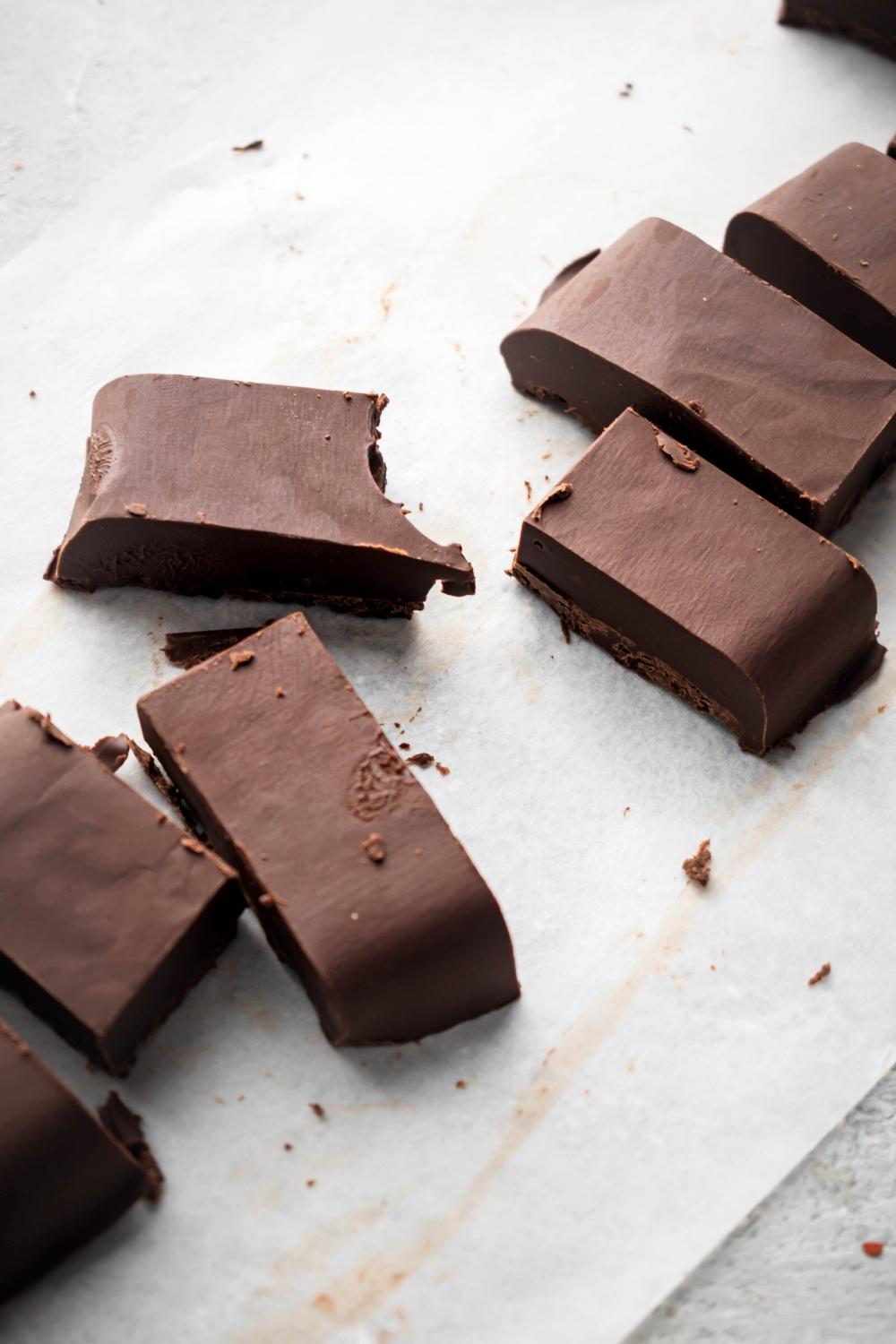 A couple of piece of Nutella fudge on a sheet of parchment paper.