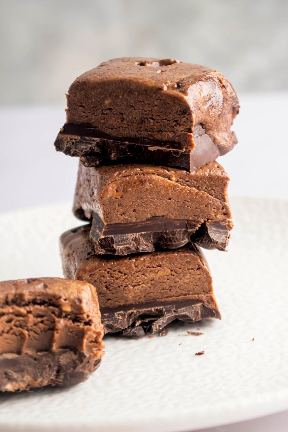 A stack of three protein brownies on a white plate.