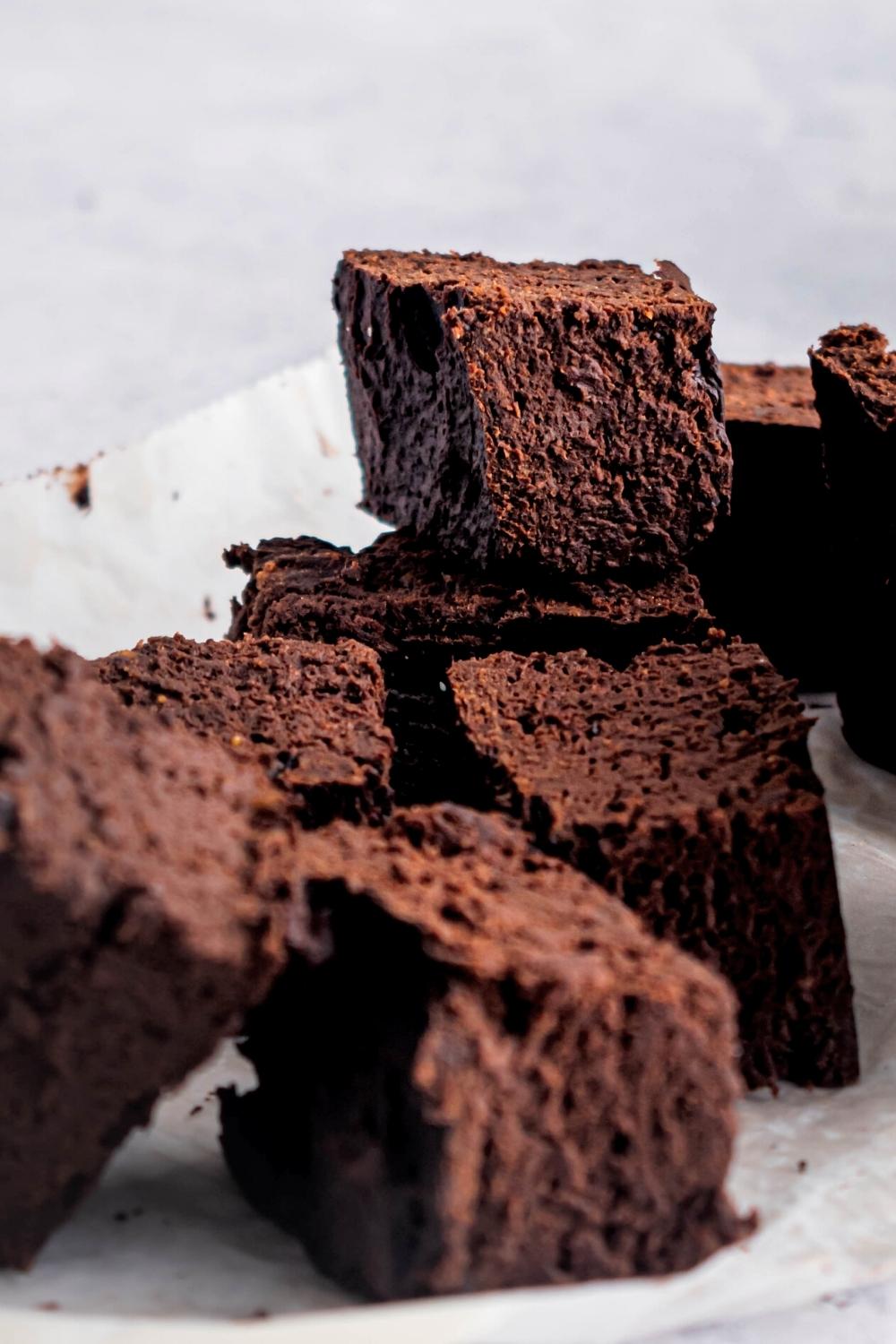 Several brownies on a piece of parchment paper.