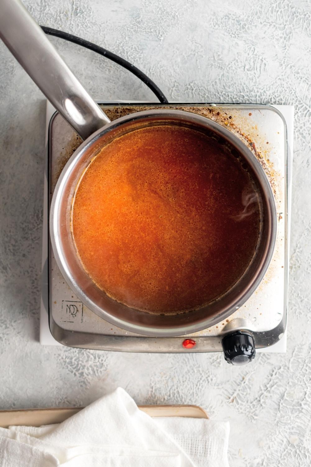 Sopa de conchas in a pot on top of a burner.