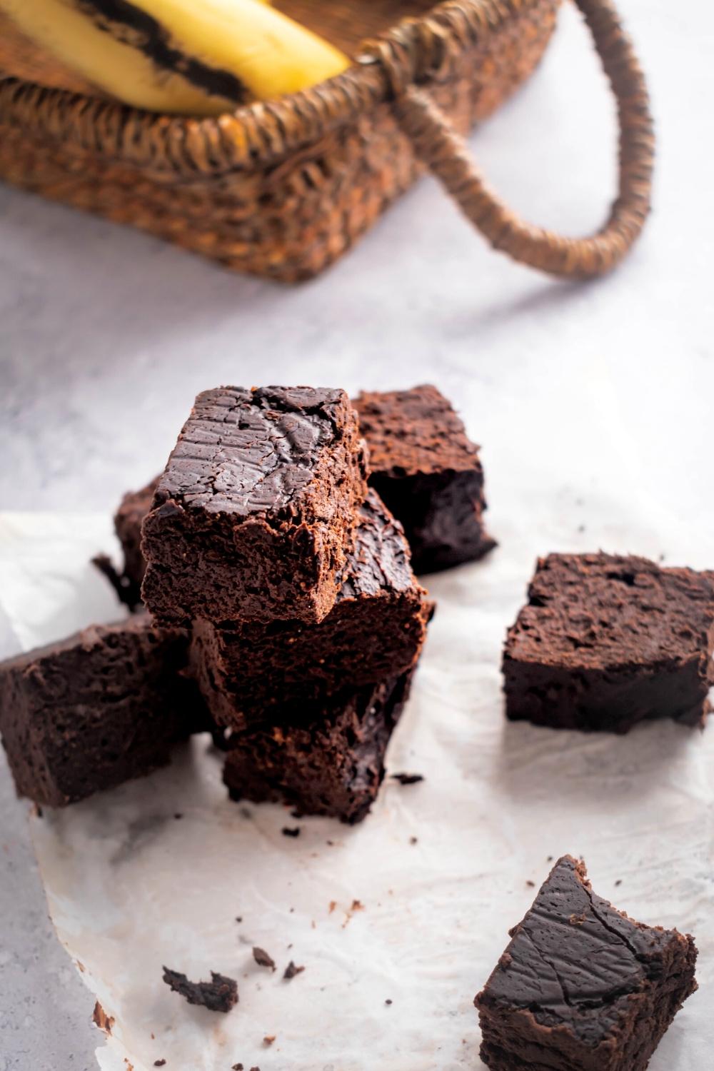 I couple of healthy brownies and a piece of parchment paper on a white counter.