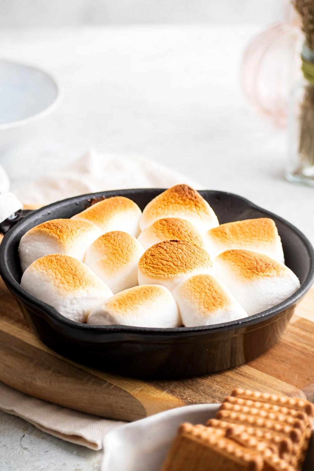 I toasted golden marshmallows in a cast iron skillet on a wooden cutting board.