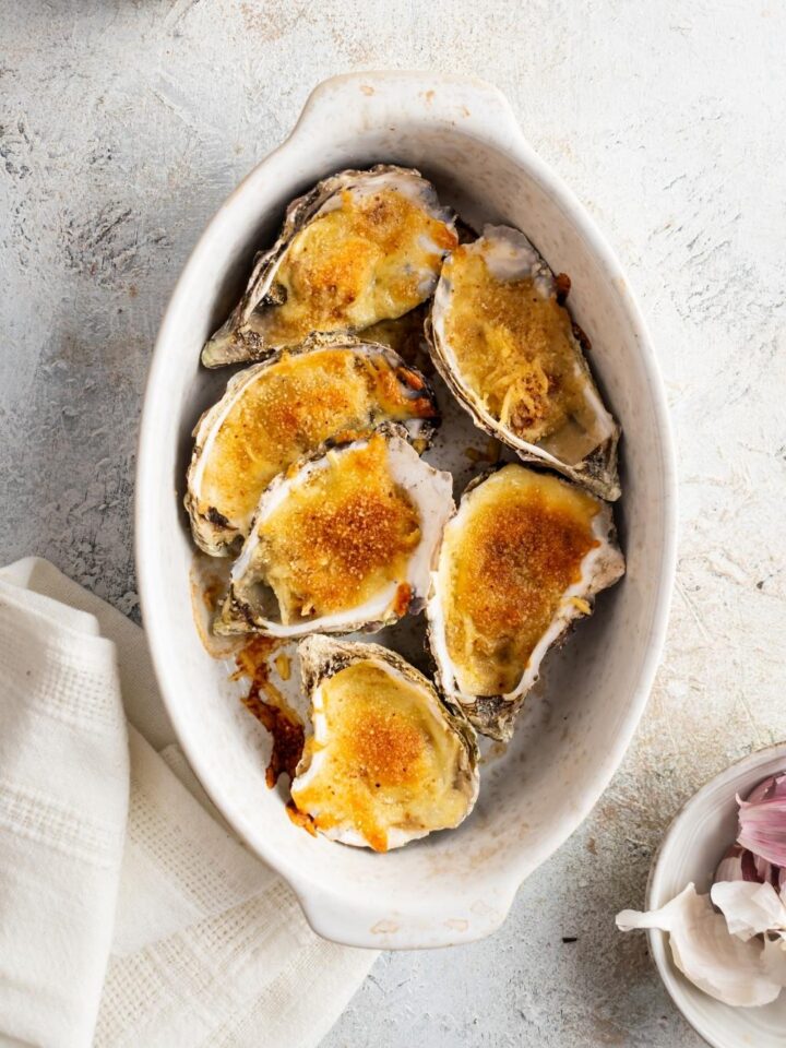 Six baked talaba in a white baking dish.