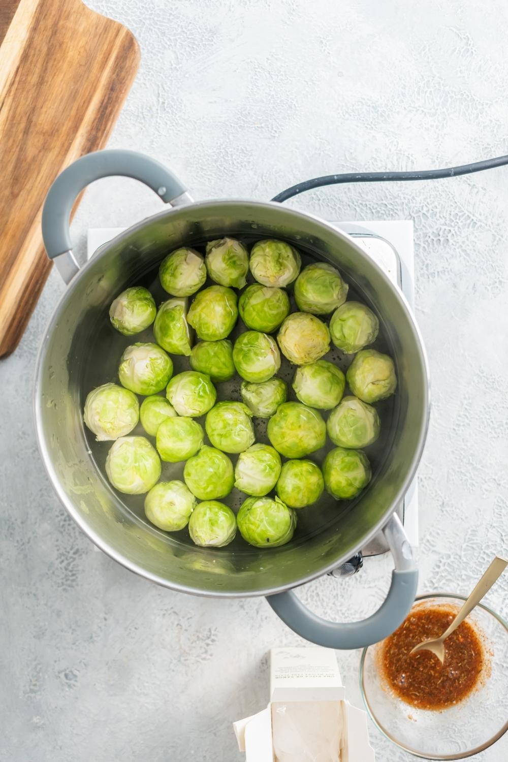 Brussel sprouts in a pot of water.