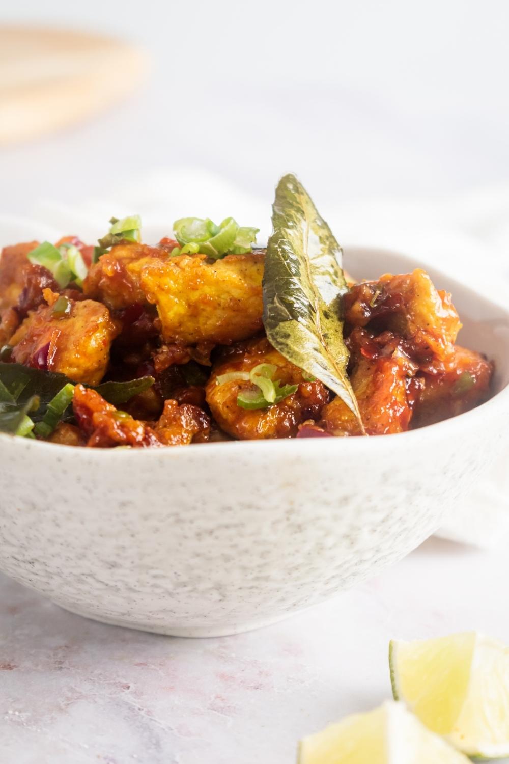 A bowl of chicken 65 on a white counter.