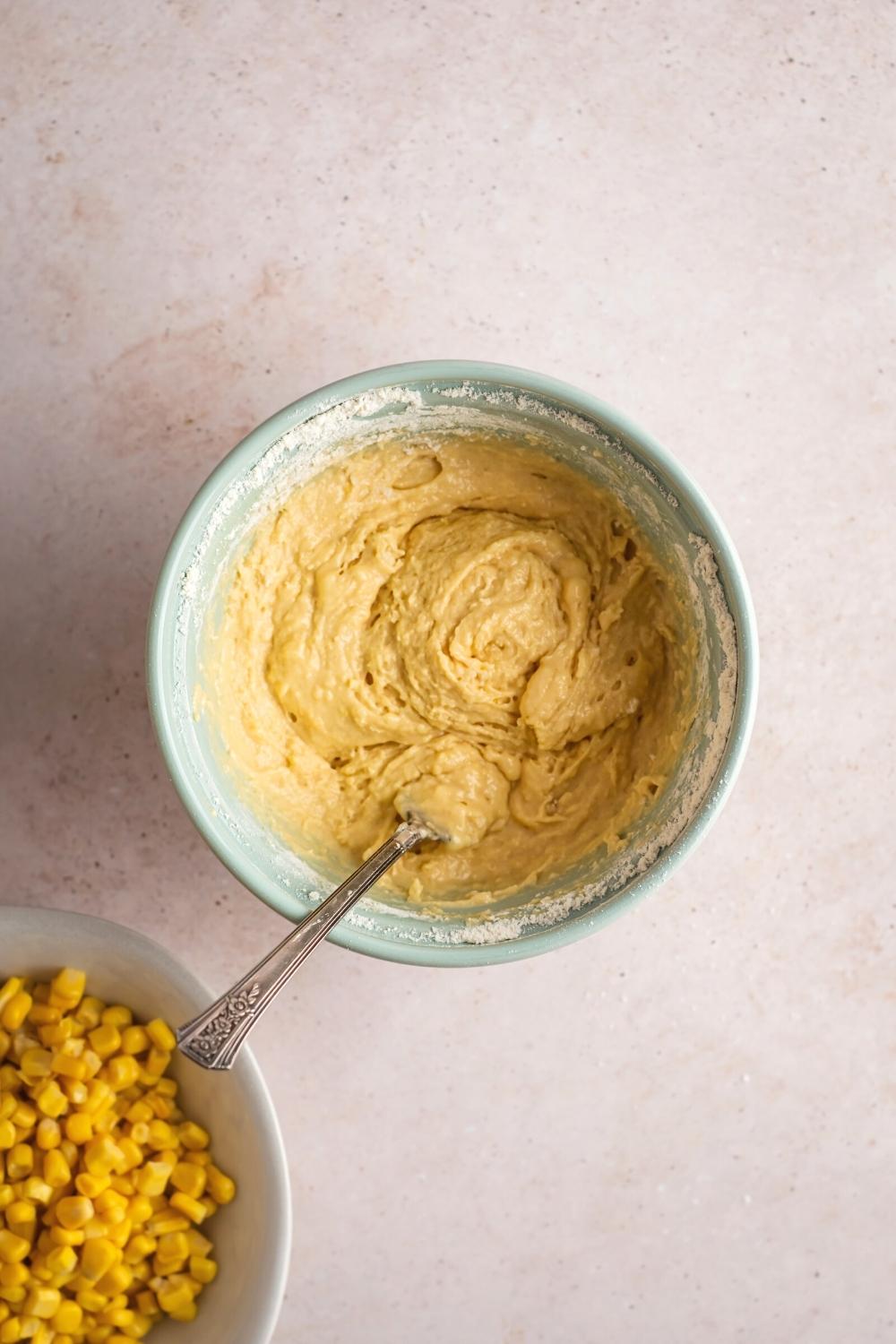 Corn nugget mixture in a bowl. Behind it is part of a bowl filled with corn.