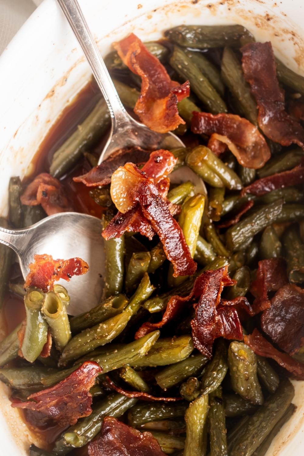 A few pieces of crispy bacon and green beans and white casserole dish.