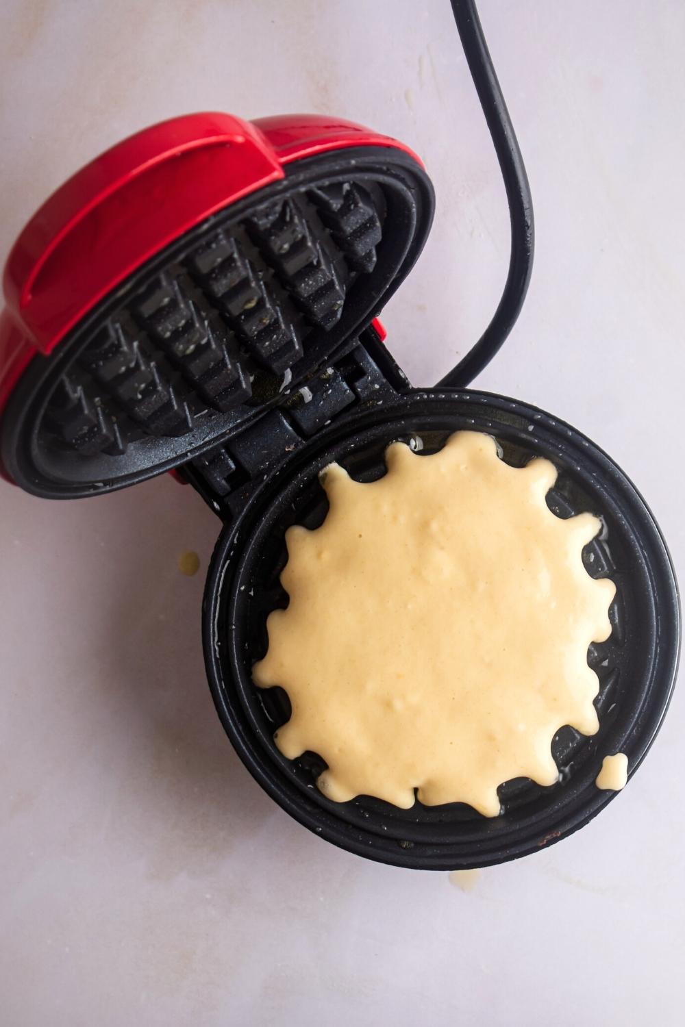 Waffle batter in a opened waffle iron.